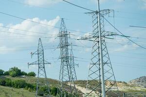 High voltage towers with sky background. Power line support with wires for electricity transmission. High voltage grid tower with wire cable at distribution station. Energy industry, energy saving photo