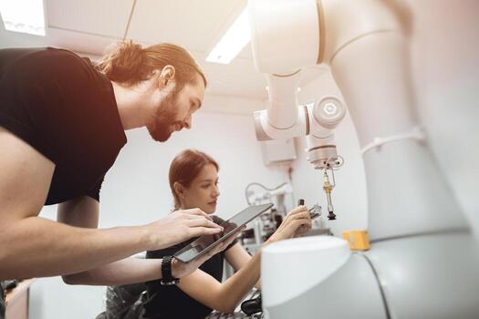 Industrial Robotics program university students learning education mechanical assembly with Robot Universal Training Platform robot arm simulation model in engineering lab classroom. photo