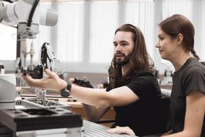 Industrial Robotics program university students learning education mechanical assembly with Robot Universal Training Platform robot arm simulation model in engineering lab classroom. photo