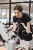 Engineer women learning education in Industrial Robotics program with robot arm simulation model in university engineering lab classroom. photo