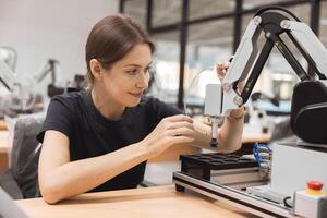 Engineer women learning education in Industrial Robotics program with robot arm simulation model in university engineering lab classroom. photo