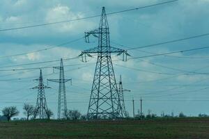 High voltage towers with sky background. Power line support with wires for electricity transmission. High voltage grid tower with wire cable at distribution station. Energy industry, energy saving photo
