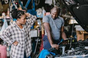 Mechanic man talking with stress worry customer inform explain car problem, service detail hard decision in garage. photo