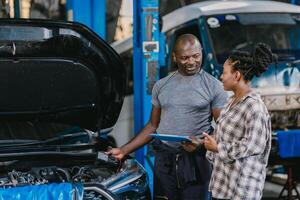 Mechanic man talking with customer inform explain car problem, service detail in garage. photo