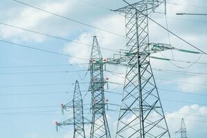 High voltage towers with sky background. Power line support with wires for electricity transmission. High voltage grid tower with wire cable at distribution station. Energy industry, energy saving photo