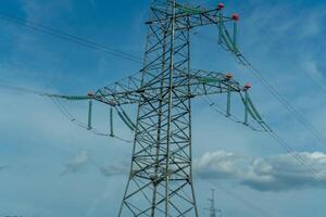 High voltage towers with sky background. Power line support with wires for electricity transmission. High voltage grid tower with wire cable at distribution station. Energy industry, energy saving photo