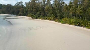 Aerial View Of The Text 'SUBSCRIBE' Written On White Sandy Tropical Beach. video