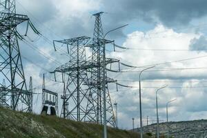 High voltage towers with sky background. Power line support with wires for electricity transmission. High voltage grid tower with wire cable at distribution station. Energy industry, energy saving photo