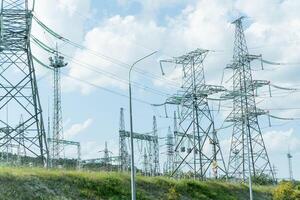 High voltage towers with sky background. Power line support with wires for electricity transmission. High voltage grid tower with wire cable at distribution station. Energy industry, energy saving photo
