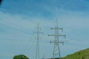 High voltage towers with sky background. Power line support with wires for electricity transmission. High voltage grid tower with wire cable at distribution station. Energy industry, energy saving photo