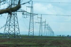 High voltage towers with sky background. Power line support with wires for electricity transmission. High voltage grid tower with wire cable at distribution station. Energy industry, energy saving photo