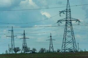High voltage towers with sky background. Power line support with wires for electricity transmission. High voltage grid tower with wire cable at distribution station. Energy industry, energy saving photo