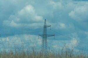 High voltage towers with sky background. Power line support with wires for electricity transmission. High voltage grid tower with wire cable at distribution station. Energy industry, energy saving photo