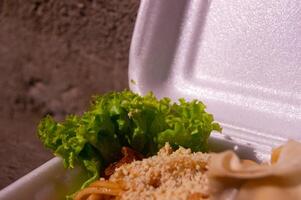 noodle dish from Indonesia, with spices and a mixture of sweet soy sauce. as well as toppings and vegetables. Noodles are sold in Styrofoam boxes photo