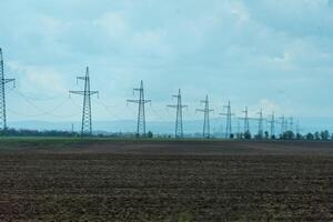 High voltage towers with sky background. Power line support with wires for electricity transmission. High voltage grid tower with wire cable at distribution station. Energy industry, energy saving photo