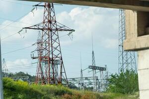 High voltage towers with sky background. Power line support with wires for electricity transmission. High voltage grid tower with wire cable at distribution station. Energy industry, energy saving photo