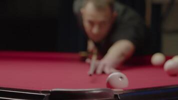 Professional billiards player rolls the cue ball into the pocket with a well-aimed and powerful shot. Medium shot. Slow motion video