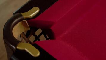 Close-up shot of a white pool ball hitting the corner pocket of a red pool table. Close up. Slow motion video