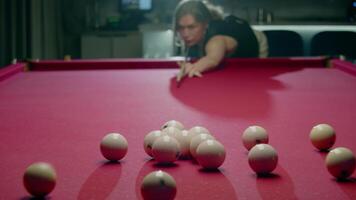 Woman with a powerful and professional stroke breaks white balls, standing in a triangle in the first stroke of a Russian billiard match. She begins the game. Mid shot. Slow motion video