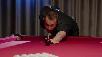 Professional Russian billiard player begins the game by hitting the cue ball, which causes it to hit other balls on the table. Close up. Slow motion video