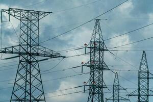 High voltage towers with sky background. Power line support with wires for electricity transmission. High voltage grid tower with wire cable at distribution station. Energy industry, energy saving photo