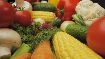 This showcases a variety of fresh vegetables, including red bell peppers, cucumbers, corn on the cob, cauliflower, mushrooms, tomatoes, onions, and raspberries. video