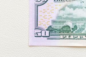 Close up shot of the US dollars note bill on the white leather background. Finance photo