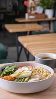 A bowl of couscous, meat, eggs and avocado with cup of coffee. Breakfast concept photo