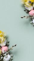 Daffodils, easter eggs and willow on green background with copy space. Easter greeting card template vertical format photo