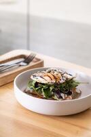 White plate with beautiful dish with salmon and egg and seeds angle view on wooden cafe table photo