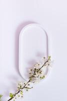 Empty podium or pedestal with spring bloom top view, flat lay. Mock up for cosmetic products photo