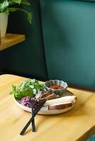 Plate of fried pork meat with sauce and greens photo