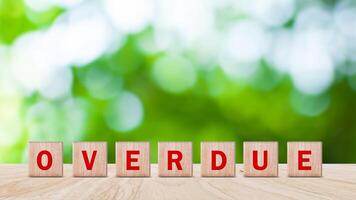 Overdue, Wooden on the office desk, informative and communication background, Word OVERDUE made with wood building blocks, OVERDUE word on block concept. photo