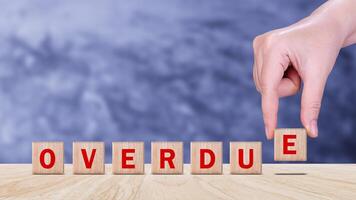 Overdue, Wooden on the office desk, informative and communication background, Word OVERDUE made with wood building blocks, OVERDUE word on block concept. photo