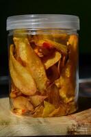 Keripik Singkong pedas or spicy Cassava Chips, Indonesian traditional snack. Made of cassava sliced, fried and cooked with chilli. photo