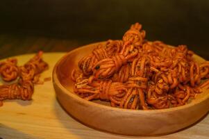 Mie gulung kering is a snack made from wheat flour and tapioca sprinkled with powdered spices. There are spicy, cheesy and original flavors. photo