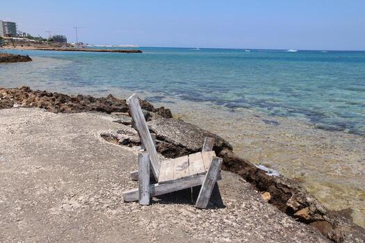 un tranquilo ver de el playa, un antiguo de madera silla y un cristal claro océano. para temas de paz, soledad y belleza de naturaleza, verano y viaje fotografía foto