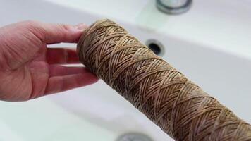 Repairman holds in his hands a dirty water filter. Replacement of the filter in the water purification filter video
