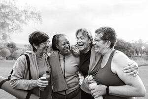 Happy multiracial senior women having fun after workout exercises in the park photo