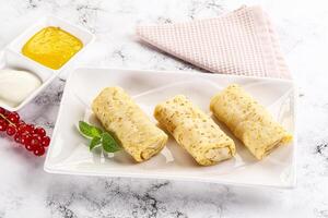 Homemade stuffed pancakes with honey and cream sour photo