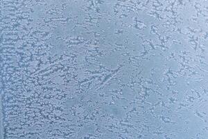 Selective focus. First frost on a frozen car, late autumn close-up. Beautiful abstract frozen microcosmos pattern. Freezing weather frost action in nature. Winter backdrop. photo