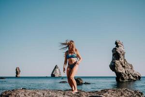 mujer mar pilates deportivo contento medio Envejecido mujer practicando aptitud en playa cerca mar, sonriente activo hembra formación en yoga estera afuera, disfrutando sano estilo de vida, armonía y meditación. foto