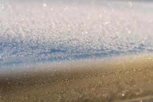 Selective focus. First frost on a frozen car, late autumn close-up. Beautiful abstract frozen microcosmos pattern. Freezing weather frost action in nature. Winter backdrop. photo