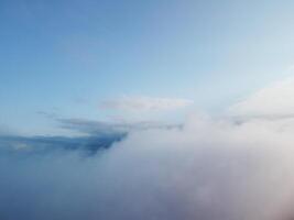Aerial view. Blue sky sun and fog over calm sea. The drone flies over foggy and fluffy clouds. Abstract aerial nature summer ocean sunset sea and sky background. Vacation, travel and holiday concept. photo