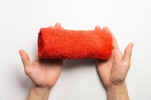Male hands holding a folded red towel on a white background photo