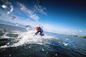professional kiter performs a difficult trick on a beautiful background of splashes, wide angle photo