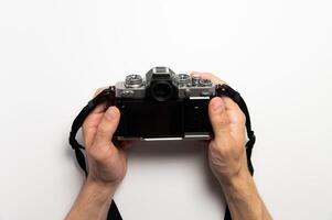 Digital SLR camera in retro style in male hands on a white background photo