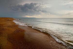 Sandy shell deserted beach in cloudy weather after rain. Buoys with rope to delimit the beach area photo