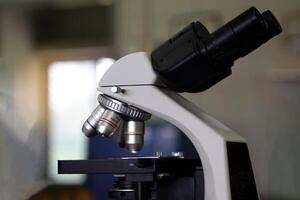 Compound Microscope focuses on the objective lens and body tube. It is a biology laboratory equipment used to magnify small objects into larger images. photo