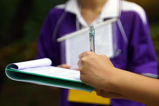 Students write down information about the trees on a document. To study the carbon storage of trees. Soft and selective focus. photo